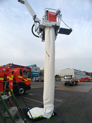 Mobile escape chute attached to a fire truck hydraulic ladder basket.