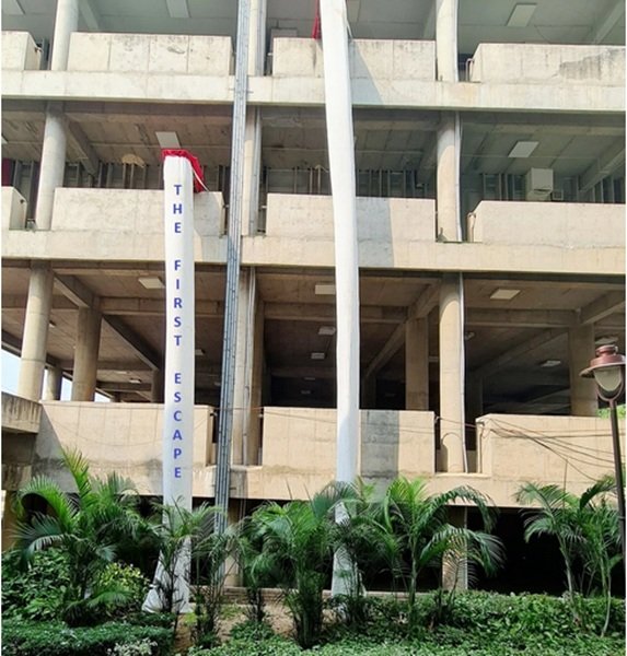 Single entry fire escape chute system installed on a commercial building balcony for emergency evacuation.